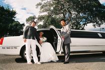 Bride and groom arriving in linousine, he is helping her out