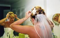 Bride getting ready, back of her plus her reflection in the mirror and in a little side mirror