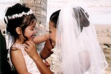 Bride with flower girl, both smiling into each other's eyes